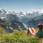 Woman hiker enjoying in panoramic view of Swiss Alps