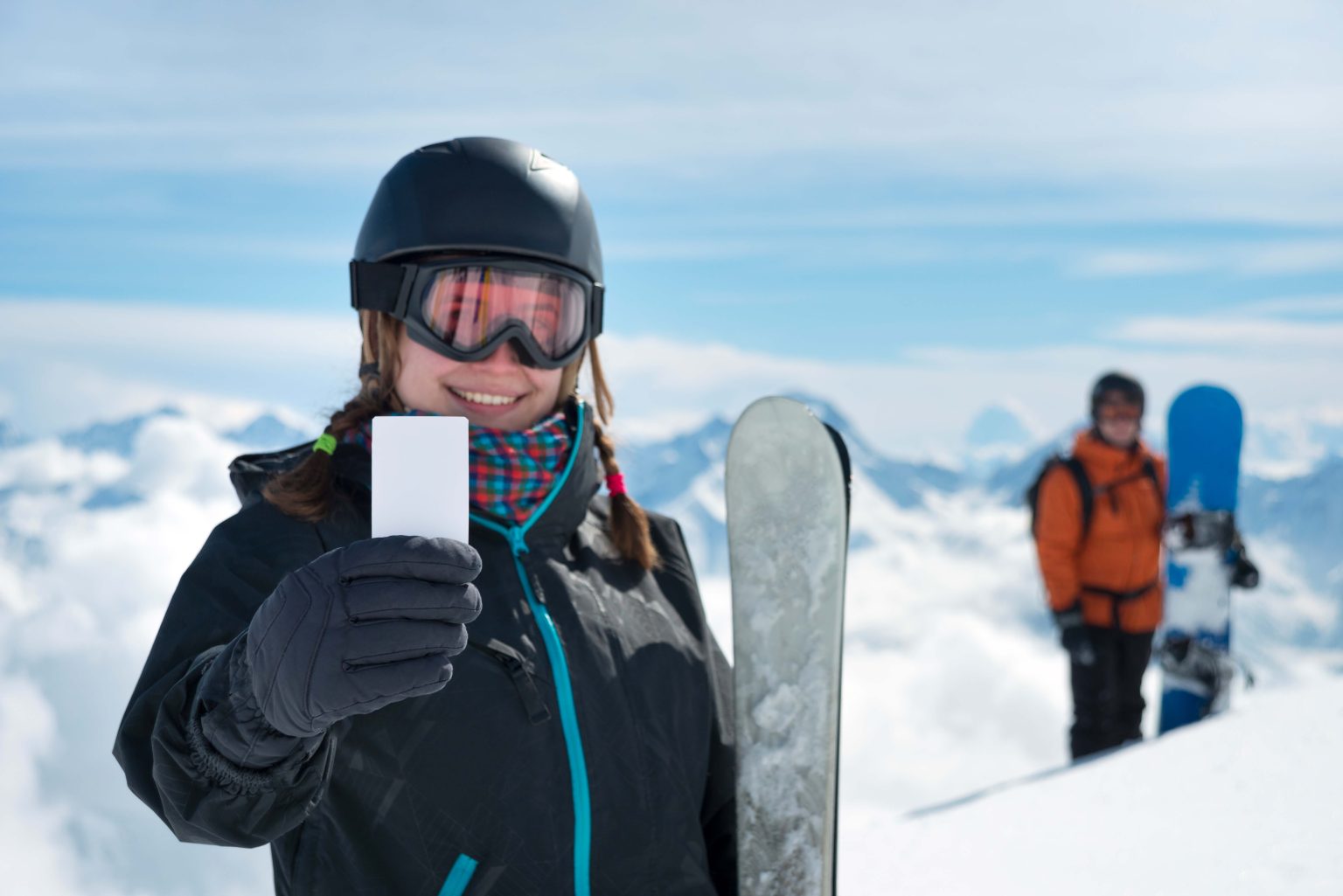 Girl holding blank ski ticket smiling